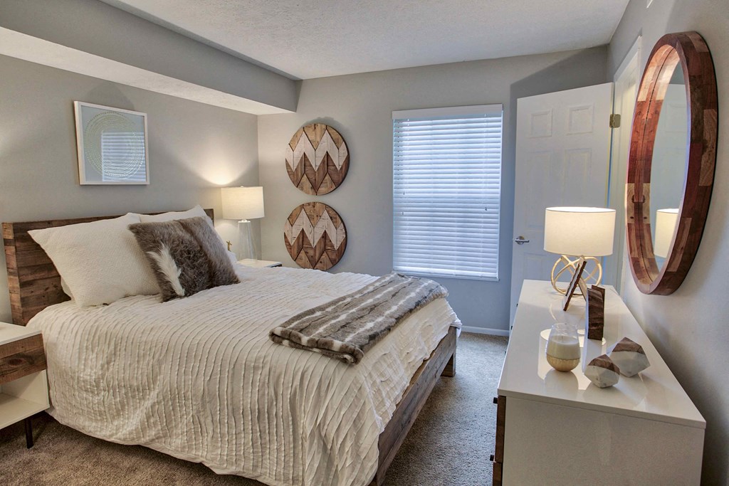 a bedroom with a bed and a dresser and a window