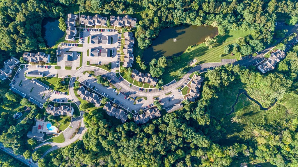 an aerial view of a resort with houses and a body of water