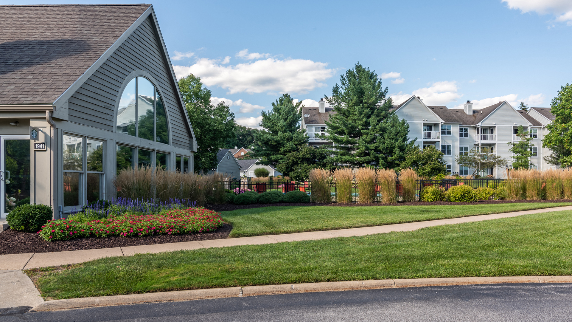 a garden in front of a building on the side of a street
