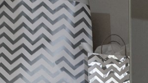 a bedroom with a bed with red and green pillows and a nightstand with