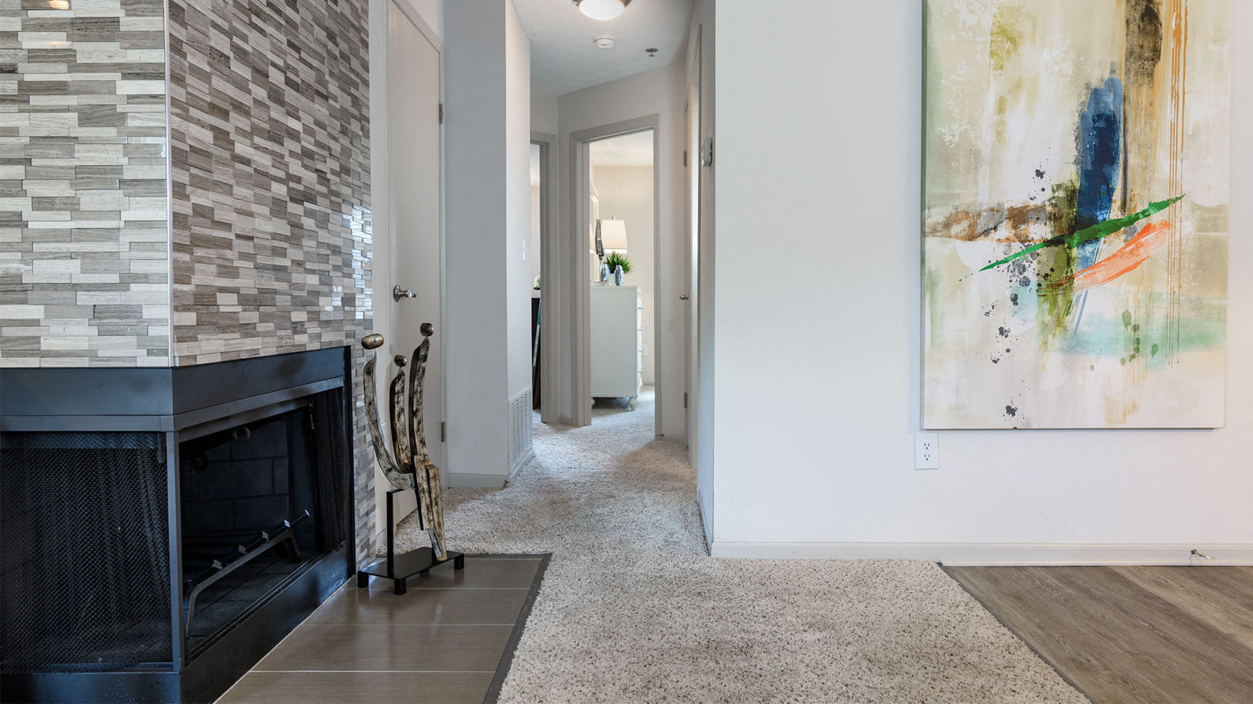 a living room with a fireplace and a painting on the wall