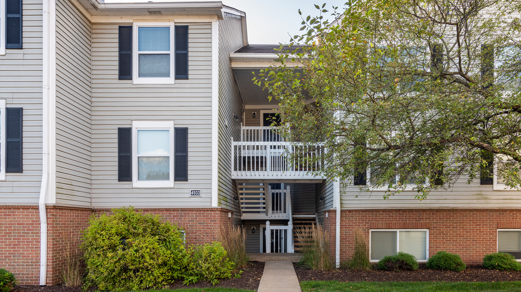 an apartment building with a sidewalk in front of it