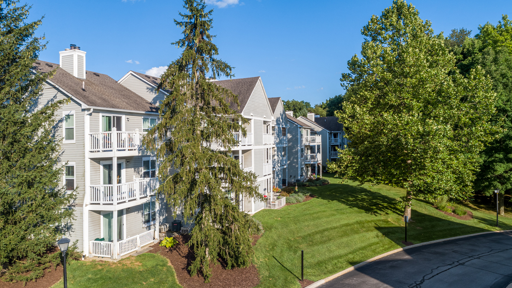 an aerial view of an apartment complex with green grass and trees