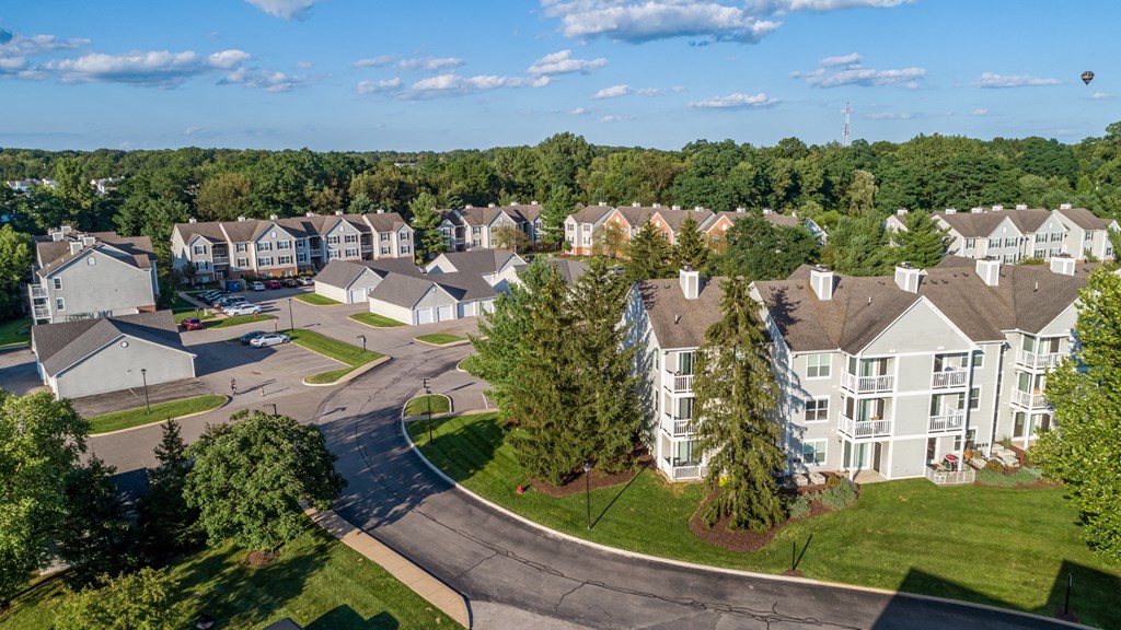 an aerial view of an apartment complex with green grass and trees
