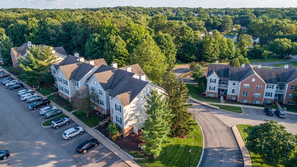an aerial view of an apartment complex with cars parked in front of it
