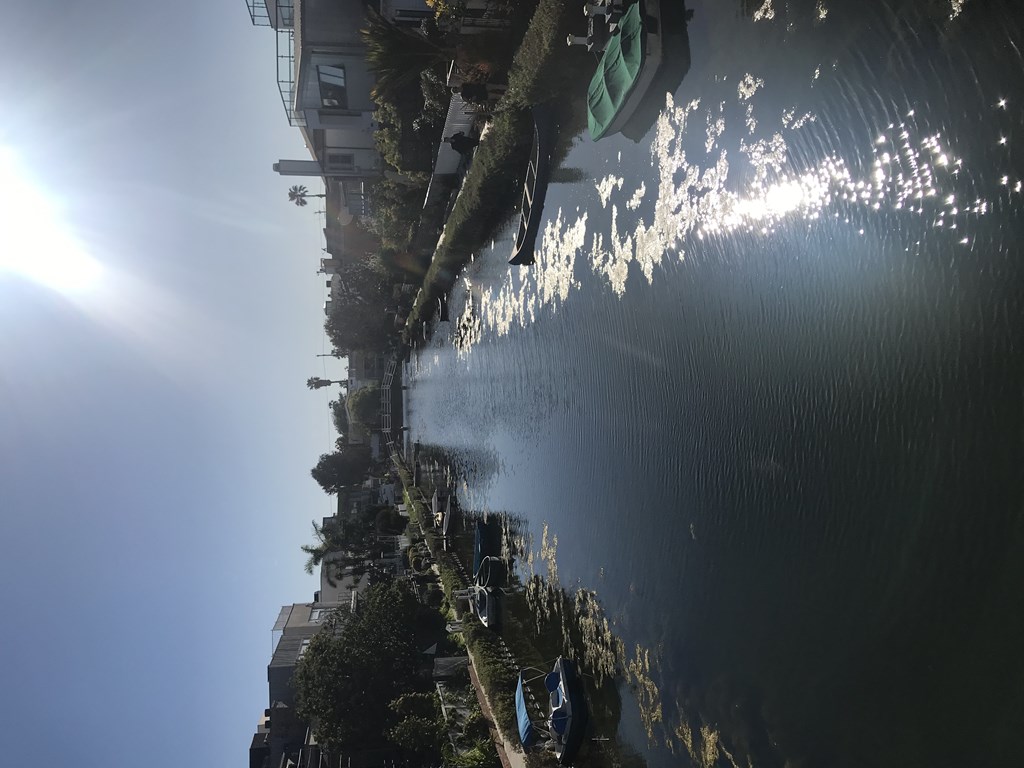 the reflection of the sun in the water next to a dock