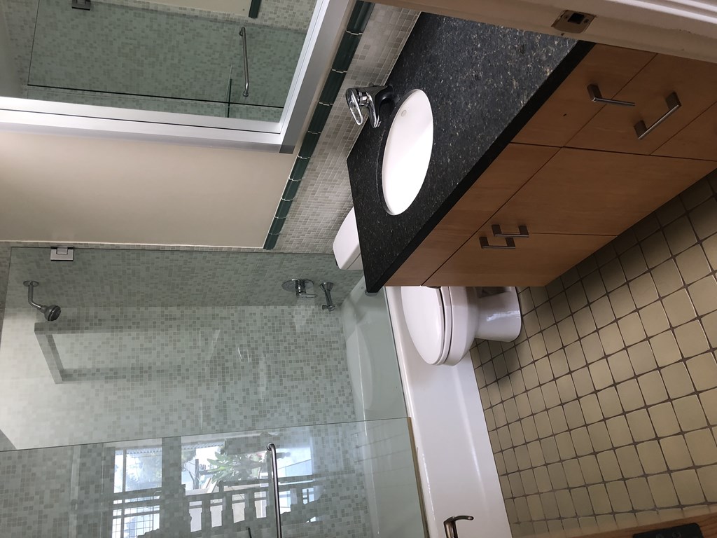 a bathroom with a toilet and a large mirror