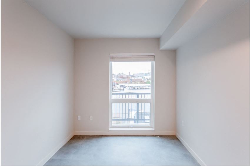 an empty room with a window overlooking a balcony