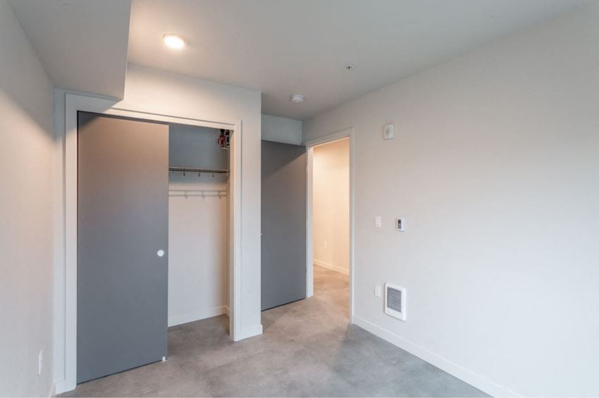 a bedroom with a closet and a door to a laundry room
