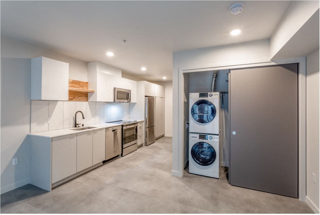 a white kitchen with a washer and dryer in it