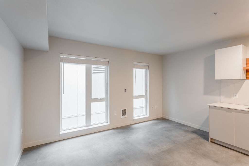 the living room of an empty house with a window and a door