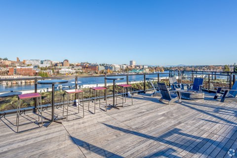 the deck on the top of the building has tables and chairs