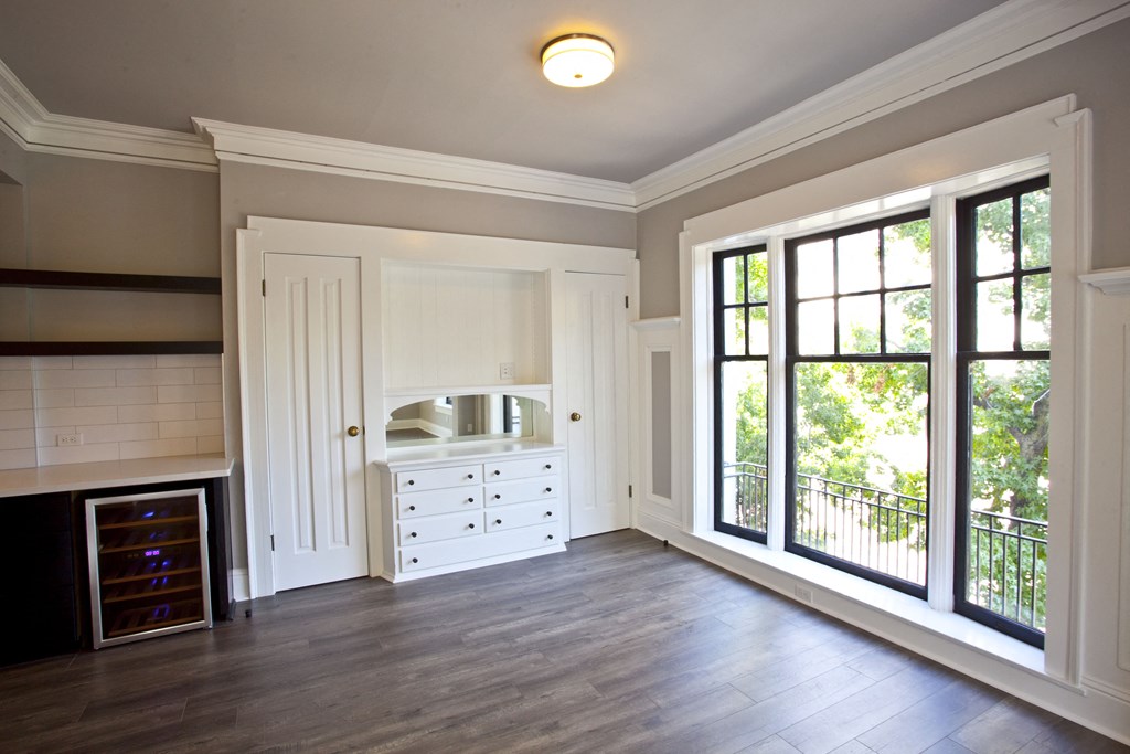 an empty living room with a fireplace and large windows