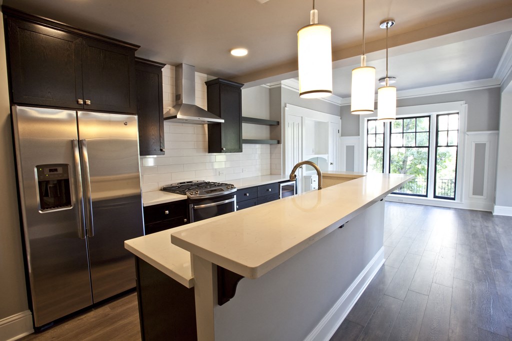 a modern kitchen with a large island and stainless steel appliances