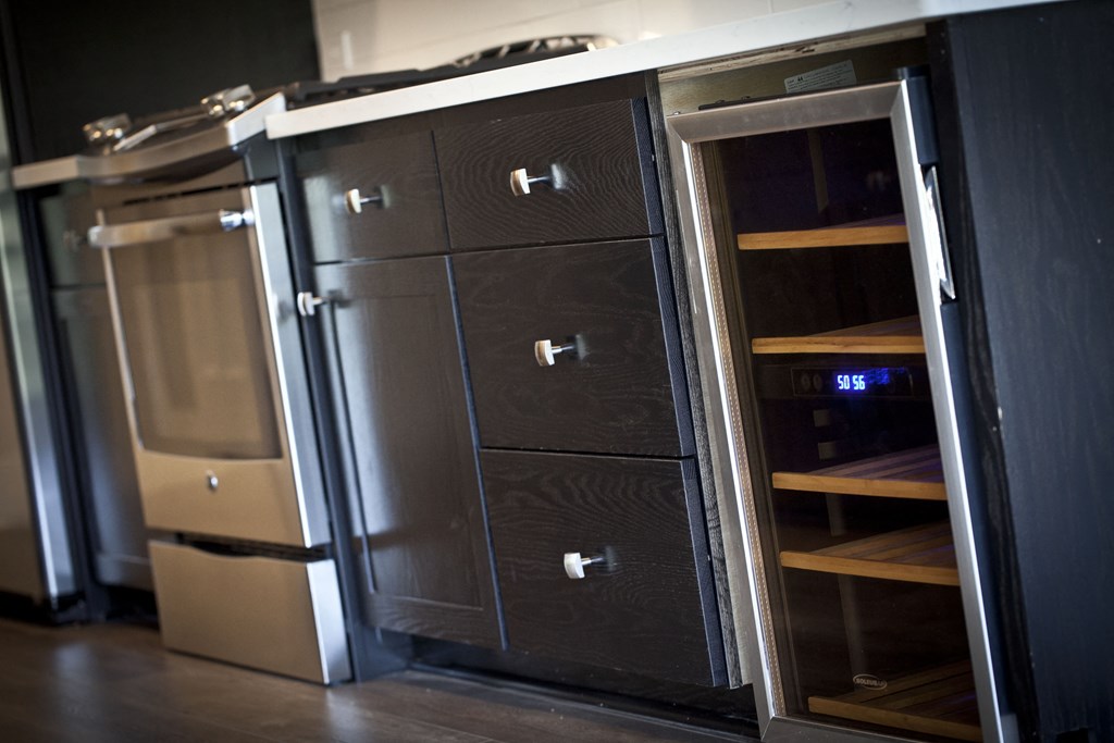 a cupboard with drawers and a refrigerator in a room