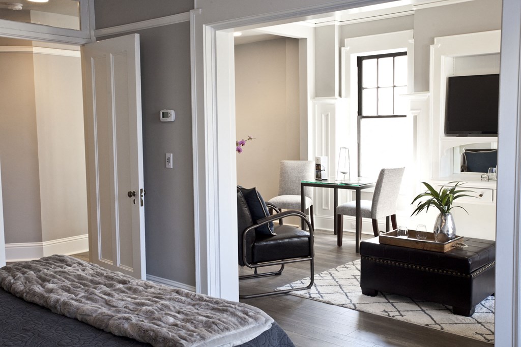 a bedroom with a bed and a living room with a table and chairs