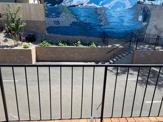 a balcony with a fence and a mural in the background