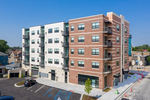 an apartment building in a parking lot with a blue sky