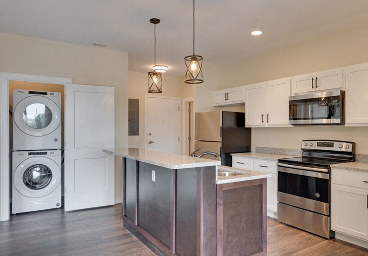 a kitchen with a washing machine and a washer and dryer