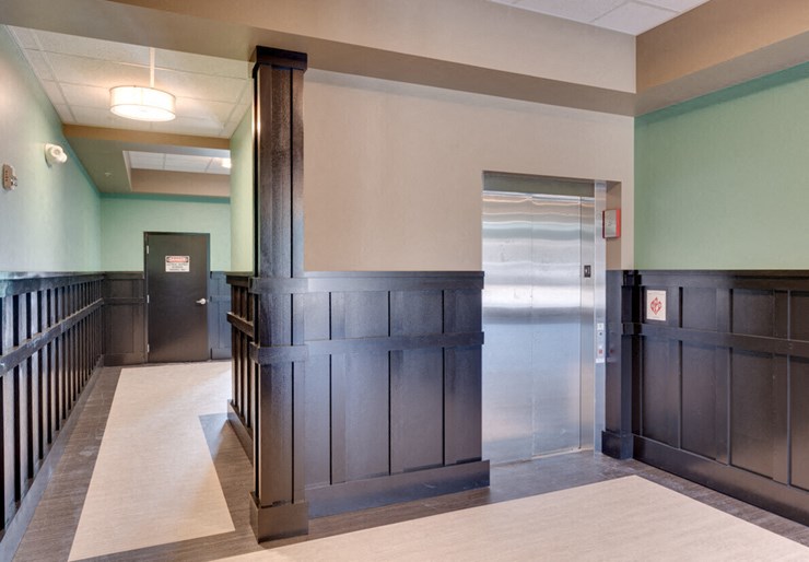 a hallway with wood paneling and a door