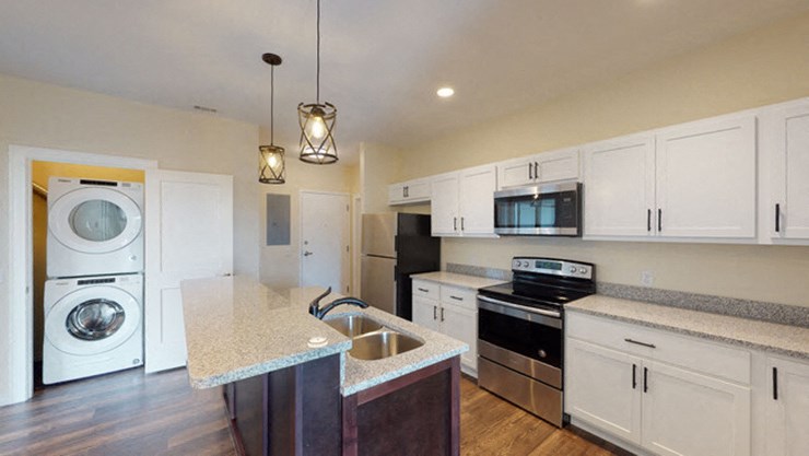 a kitchen with a washer and dryer and a sink
