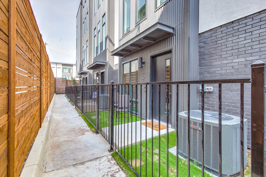 a patio with a heater and a fence in front of a building