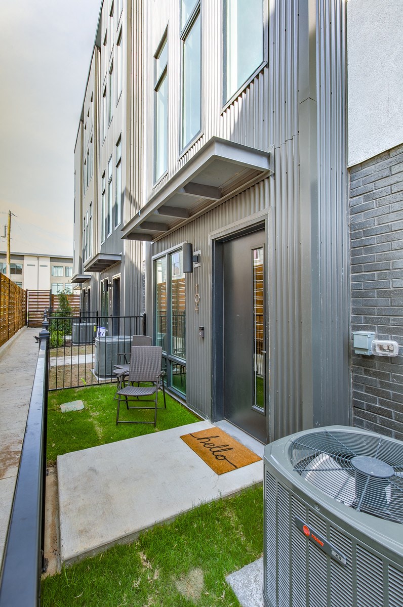 a patio with a fire pit and a building with windows