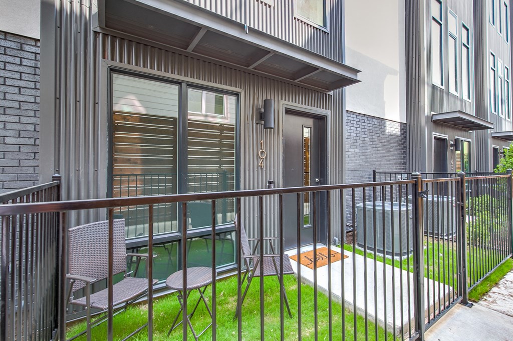 a balcony with a metal railing and chairs on it