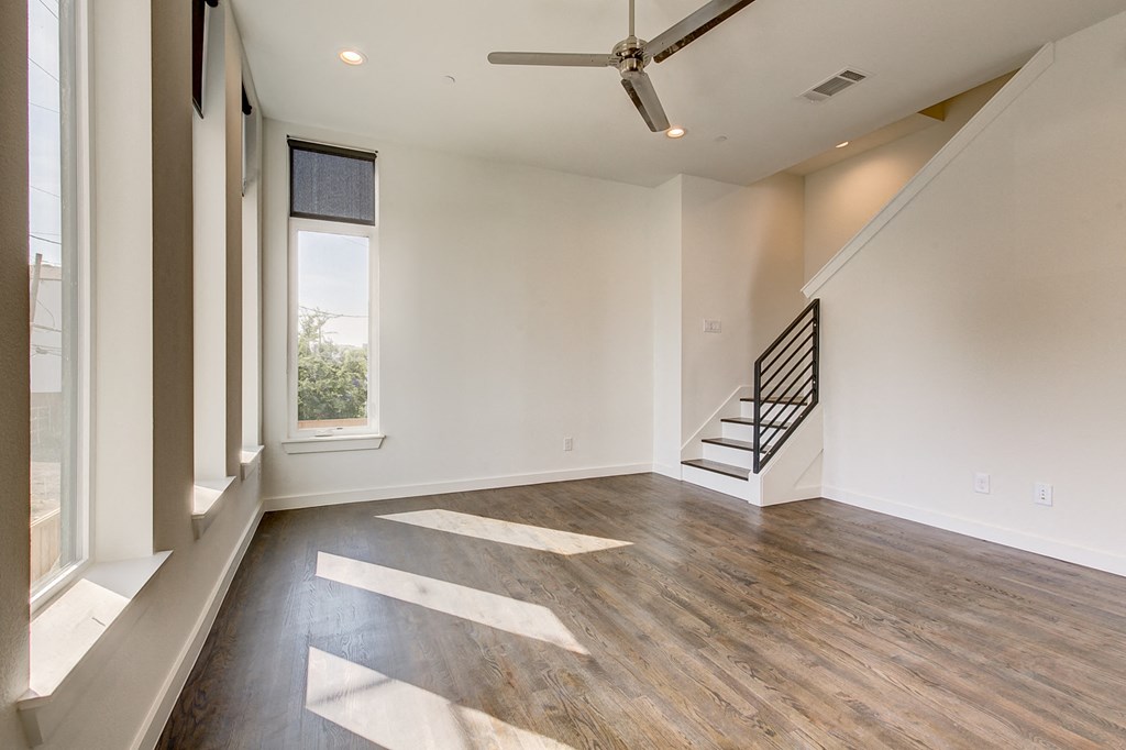an empty living room with white walls and a window