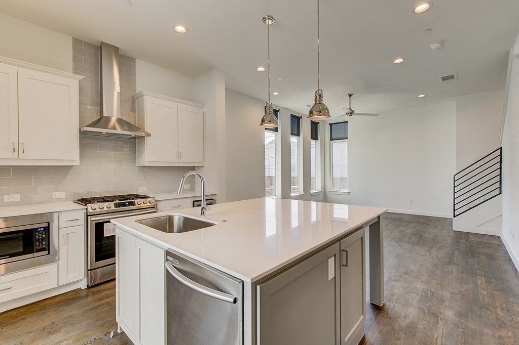 a large kitchen with an island and stainless steel appliances