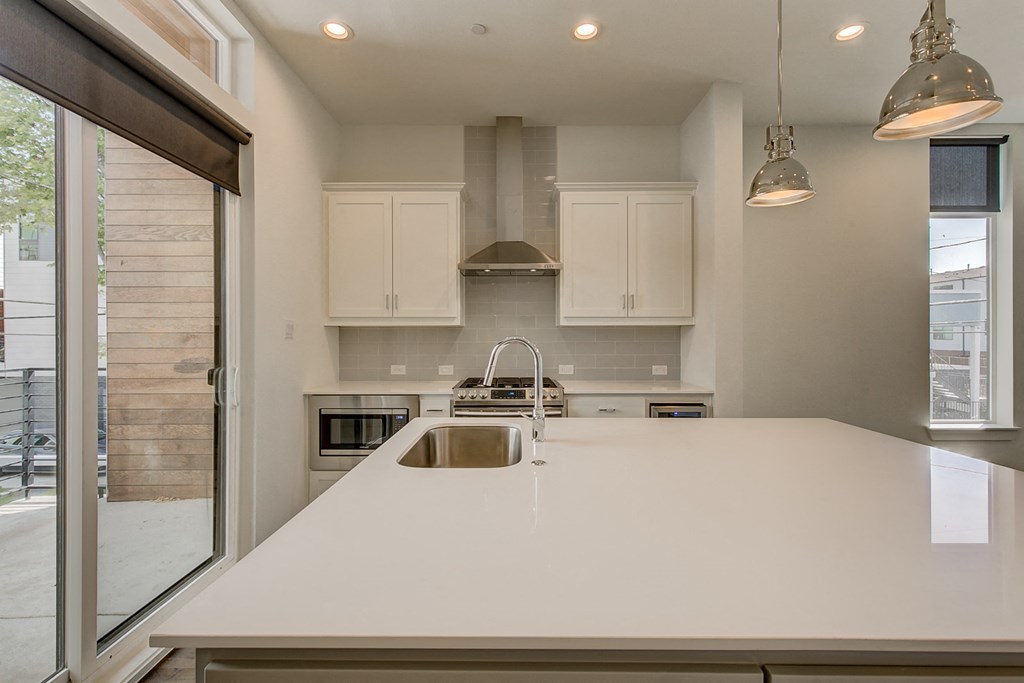 a kitchen with a white counter top and a window
