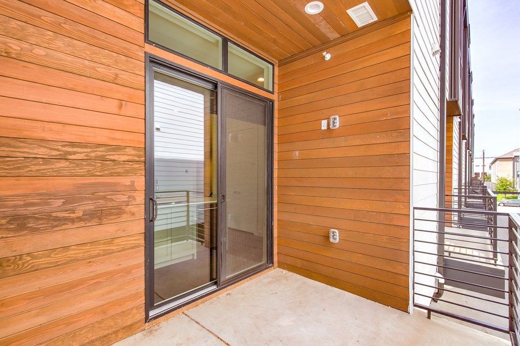 the entrance to the house has a glass door and a staircase