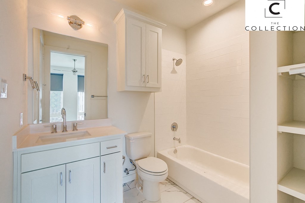 a white bathroom with a toilet and a tub and a sink