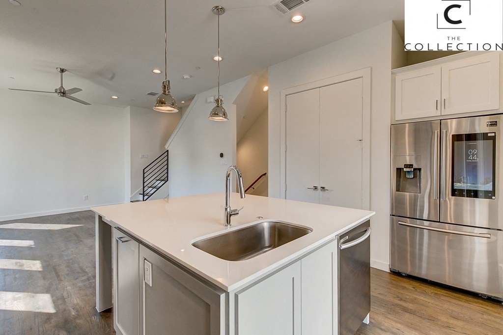 a kitchen with an island and a stainless steel refrigerator