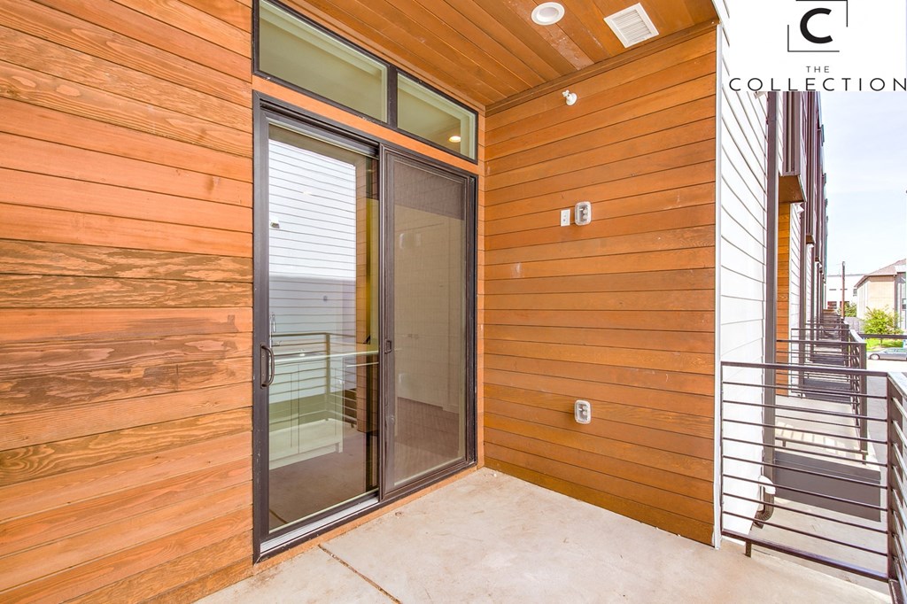 the entrance to the house has a glass door and a staircase