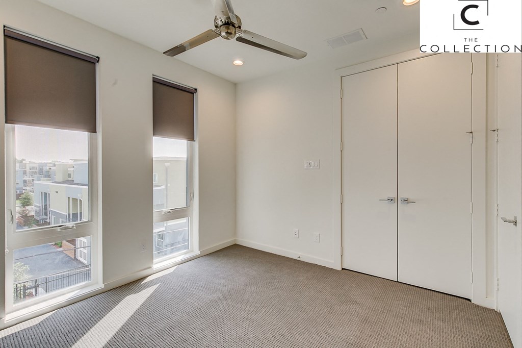 an empty room with a ceiling fan and windows