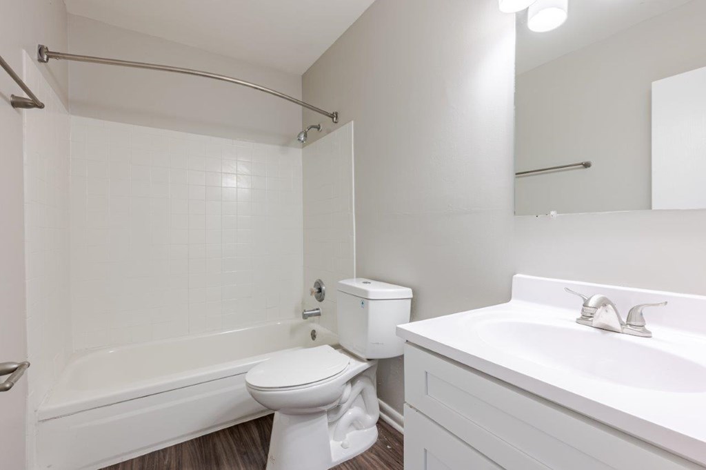 A white bathroom with a toilet, sink, and bathtub.