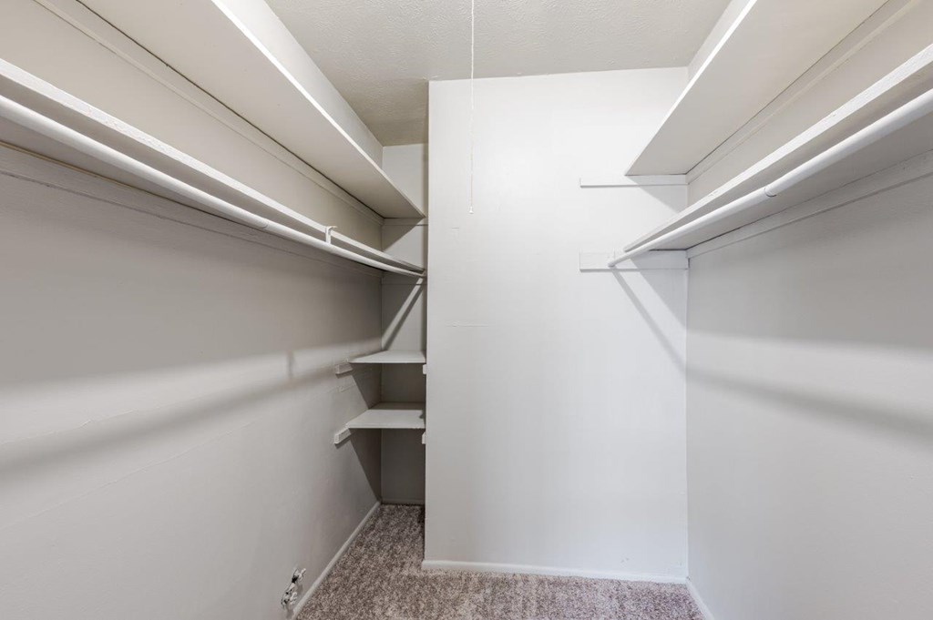 A white hallway with a carpeted floor and white walls.