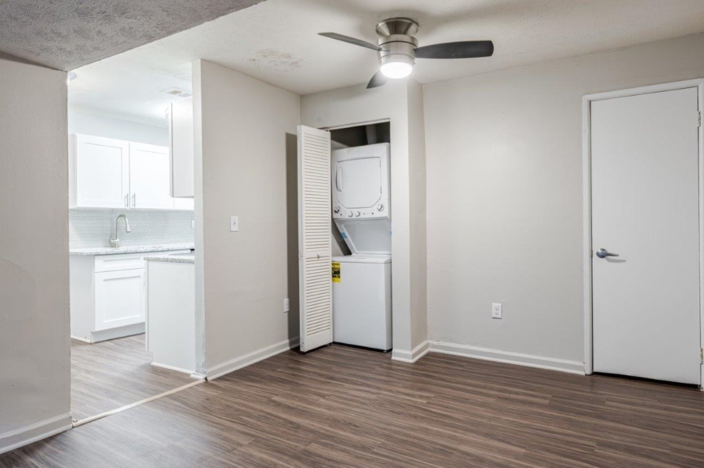 A kitchen with white appliances and a wood floor.