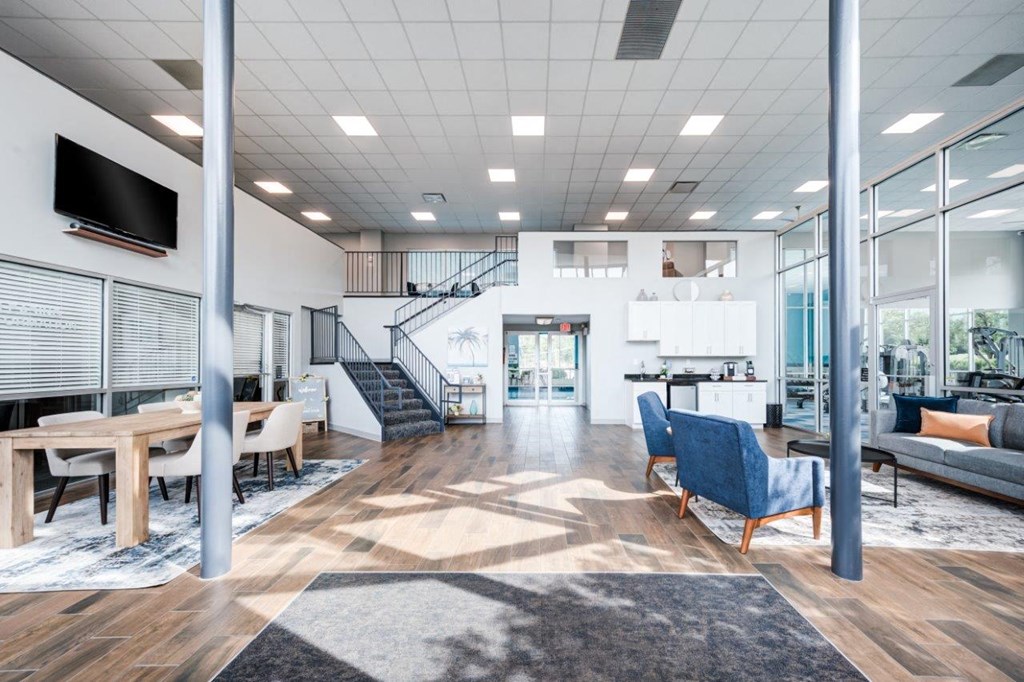 A modern living room with a staircase in the background.