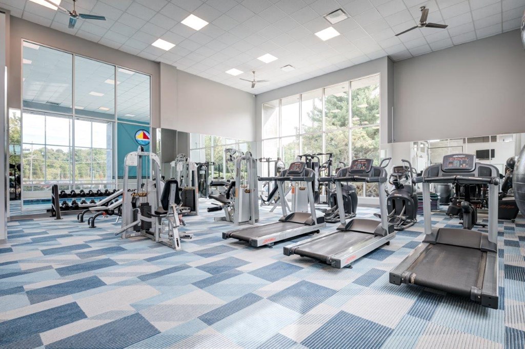 A spacious gym with a variety of equipment and a checkered floor.
