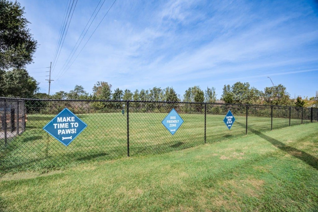 A sign in a field says "Make Time to Paws".