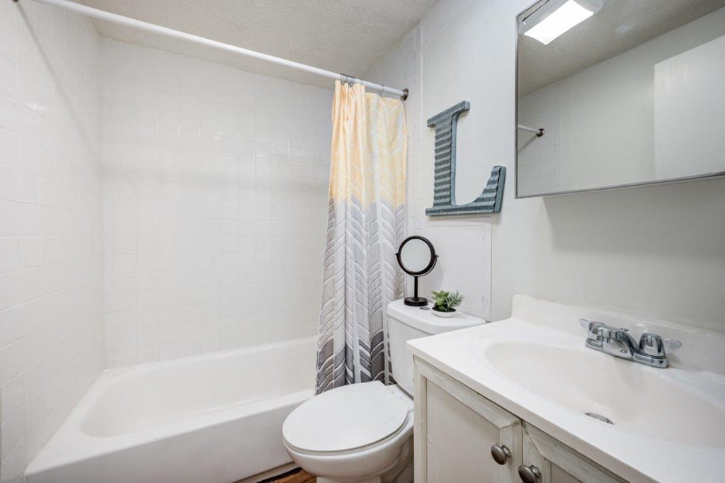 A bathroom with a white tub, toilet, and sink.