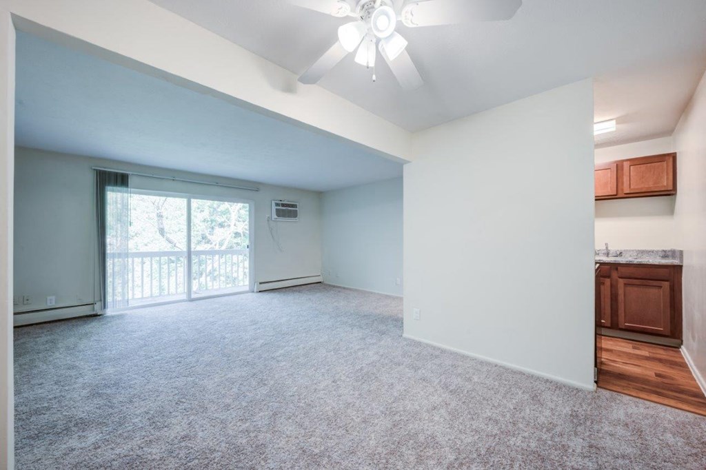 A spacious room with a ceiling fan and a window.