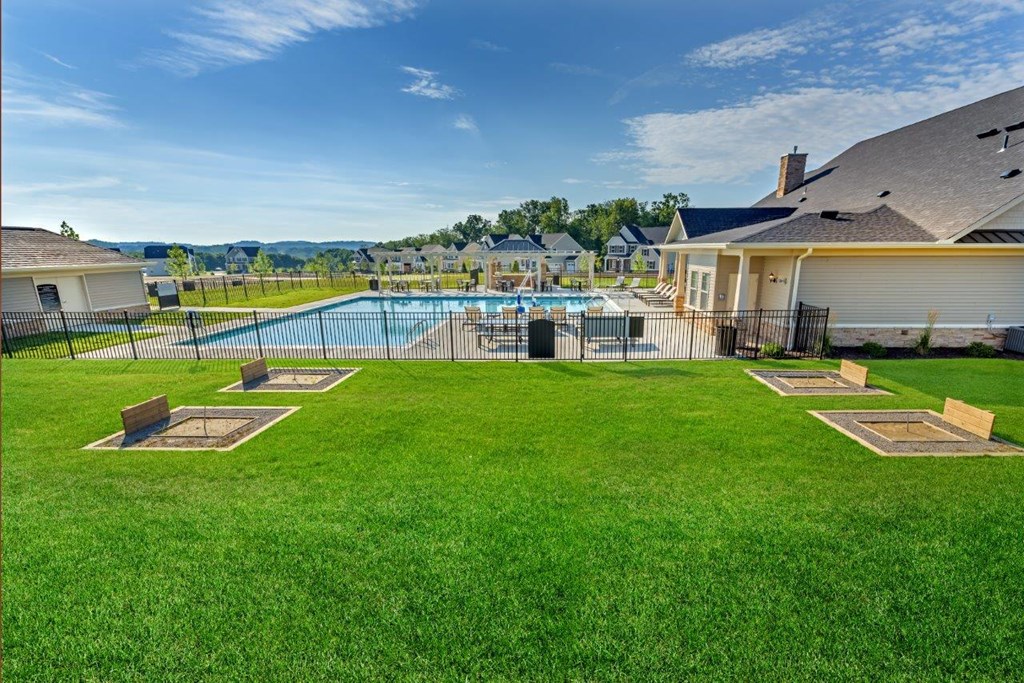 a pool with a fence in front of a house
