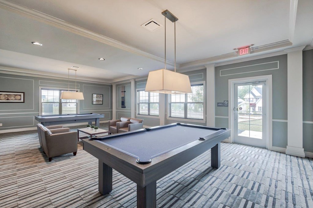 a game room with a pool table and couches