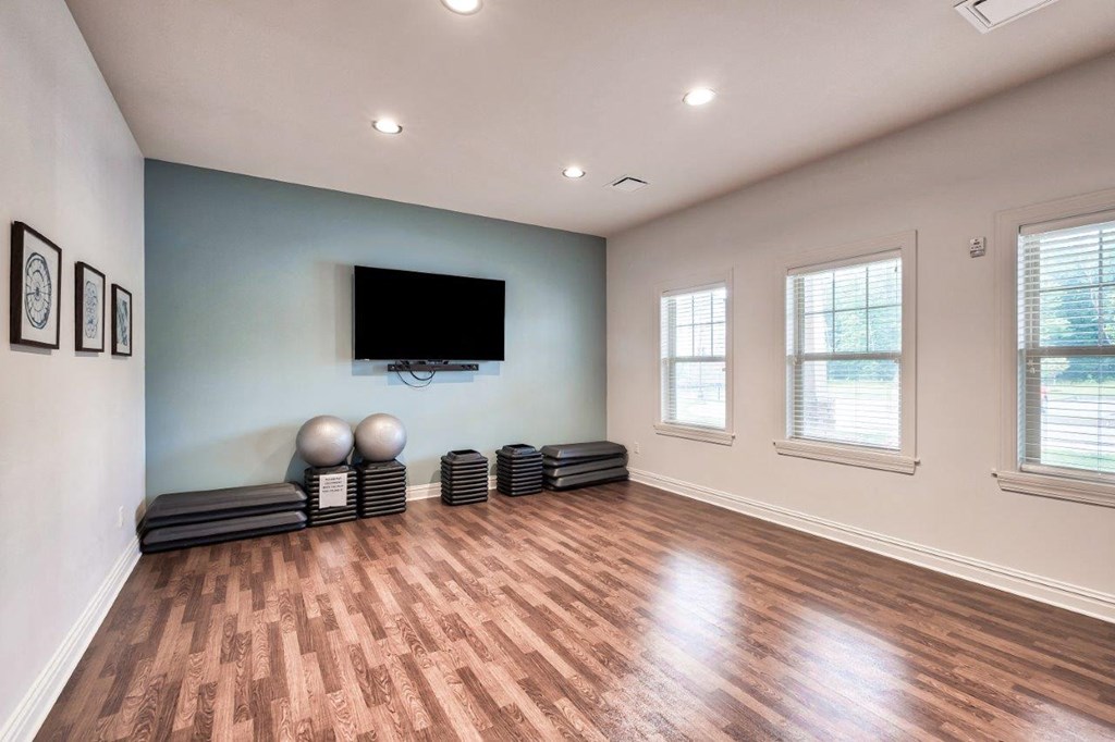 an empty living room with a tv on the wall