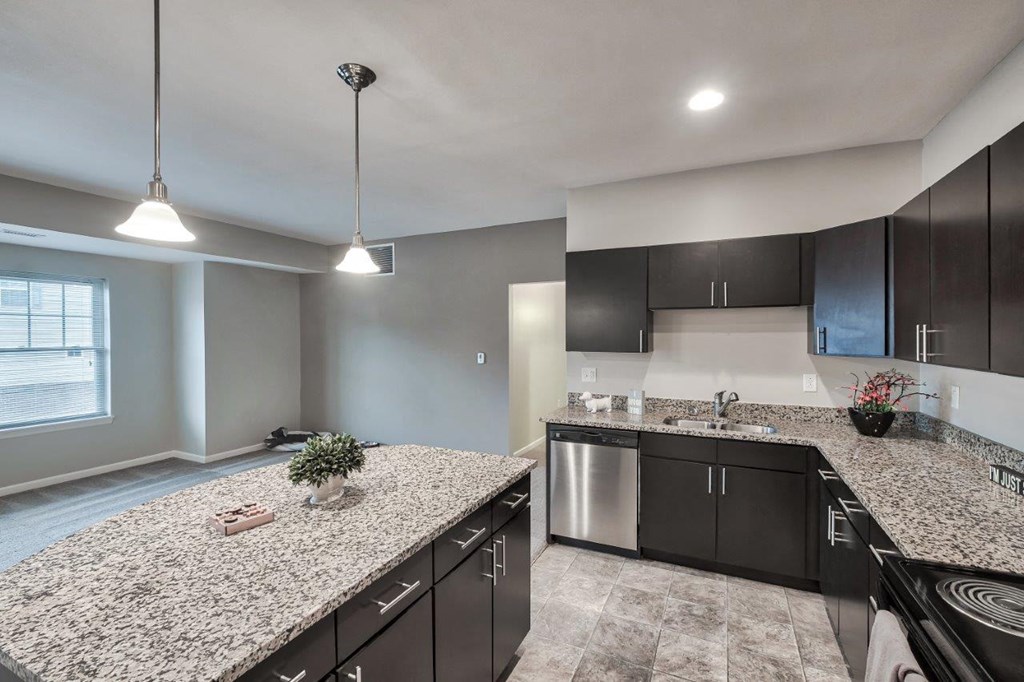 a kitchen with granite counter tops and black cabinets