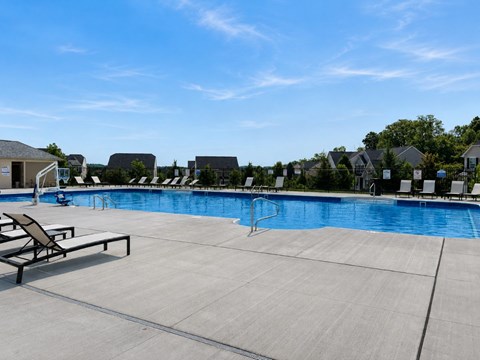 A large outdoor swimming pool with sun loungers and a slide.