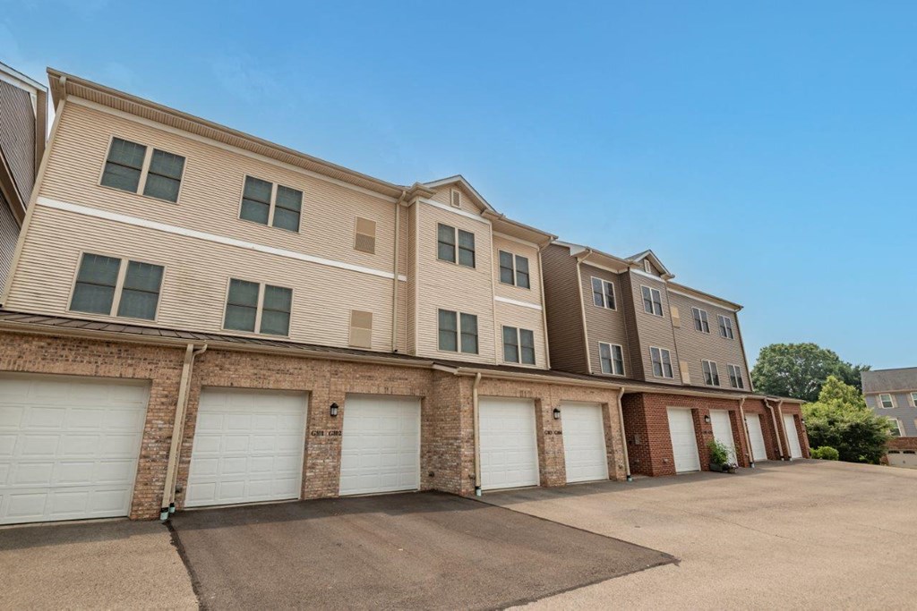 a row of apartment buildings with white garage doors
